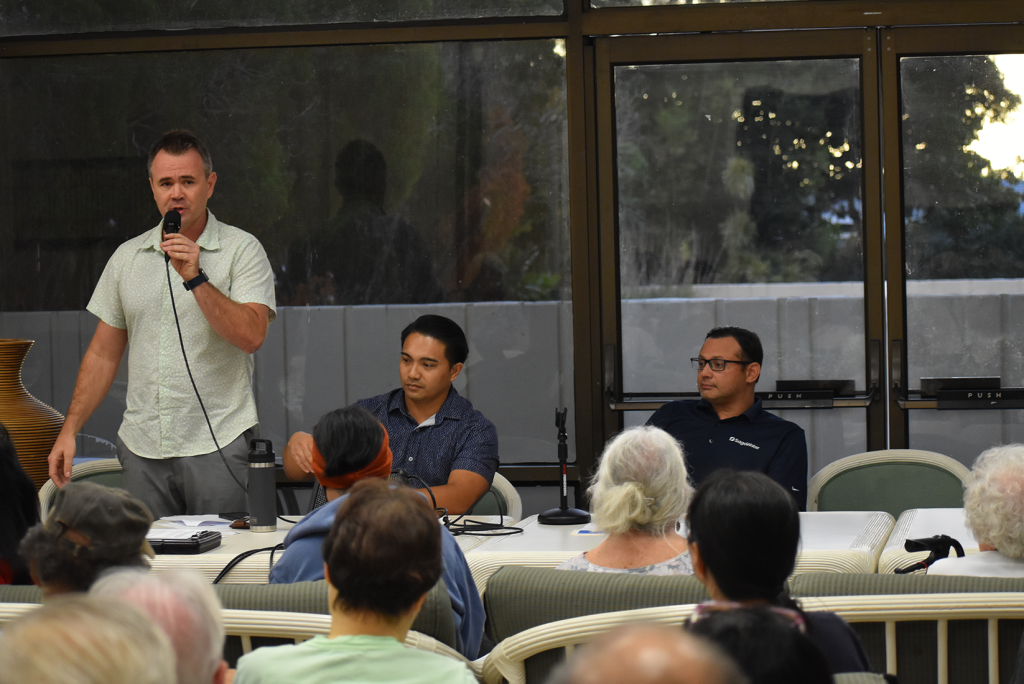 A community town hall where constructions managers and SageWater project managers are presenting the project plan to an audience of tenant-owners