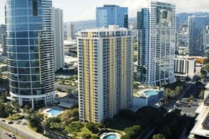 Aerial view of several high-rise residential apartment buildings and condominiums in a tropical urban area.